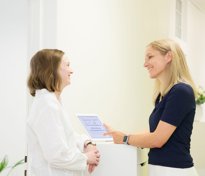 Dr. med. Kirsten Lanzerath erklärt einer Patientin etwas auf einem iPad im Diabetes Zentrum München