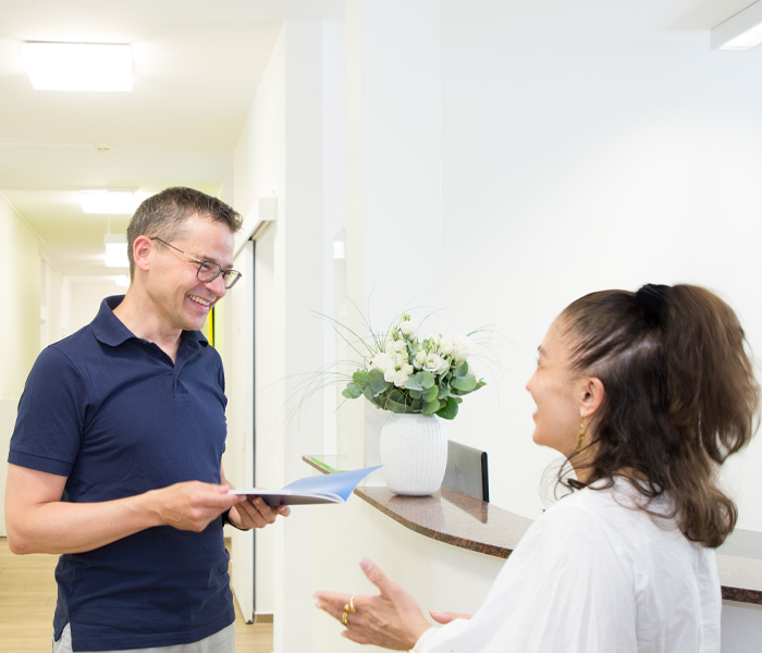 Dr. med. Christian Bergemann spricht mit einer Patientin im Gang des Diabetes Zentrums München