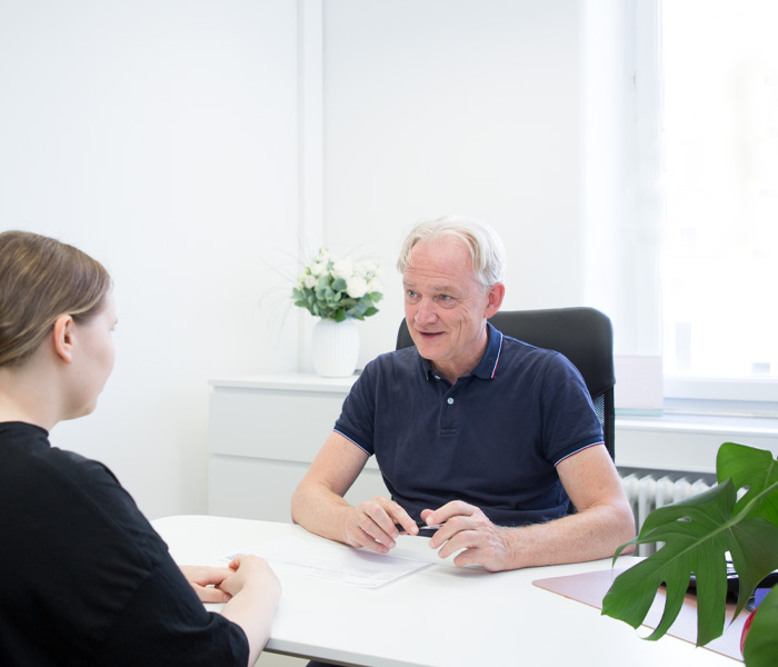 Priv. Doz. Dr. med. Martin Füchtenbusch erklärt etwas einer Patientin im Diabetes Zentrum München